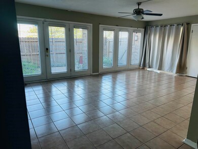 Tiled spare room with french doors and ceiling fan