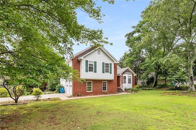 Tri-level home with brick siding, a front yard, driveway, a garage, and entry steps