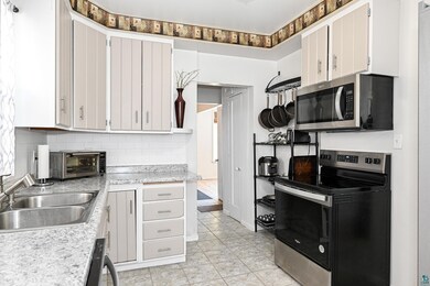 Kitchen featuring white cabinetry, sink, tasteful 