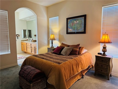 Bedroom with light colored carpet and ensuite bathroom