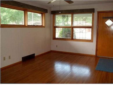 Living room with hardwood floors, large windows le