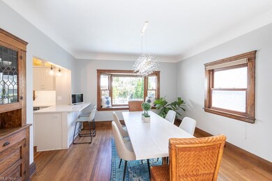 Dining room with built-in leaded glass cabinet, bay window, all open to kitchen.