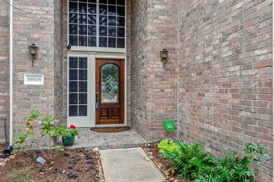 Front porch with brick flooring and a refinished front door.