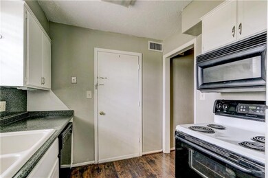 Kitchen with black appliances, a textured ceiling,