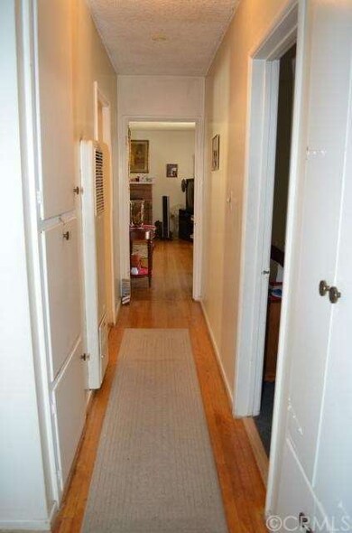 Hallway with plenty of linen closets and hard wood floors