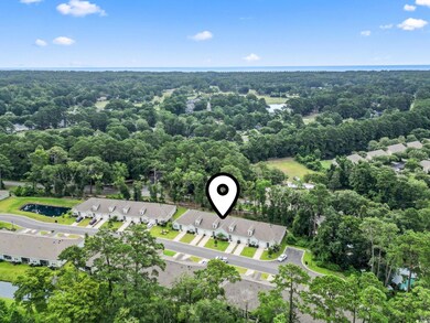 Aerial view of residential area with a heavily wooded area and a nearby body of water