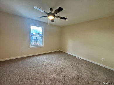 Carpeted spare room featuring baseboards