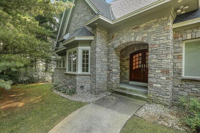 Double front entry doors open into a warm and inviting interior where craftsmanship is immediately evident.