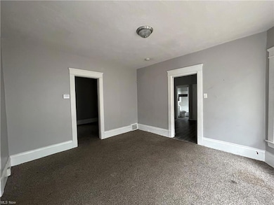 Empty room featuring dark carpet