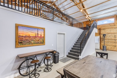 Foyer featuring a high ceiling, wood walls, and stairway