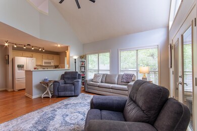 Living area featuring a ceiling fan, high vaulted 