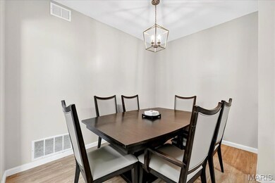 Dining area featuring light wood-type flooring and a chandelier