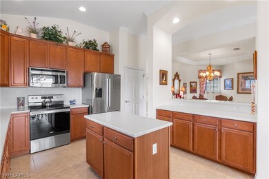 Kitchen with appliances with stainless steel finishes, a center island, light tile patterned floors, and backsplash