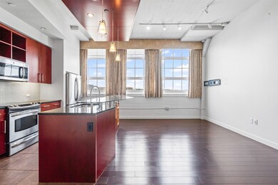 Kitchen with dark countertops, appliances with stainless steel finishes, healthy amount of natural light, and rail lighting
