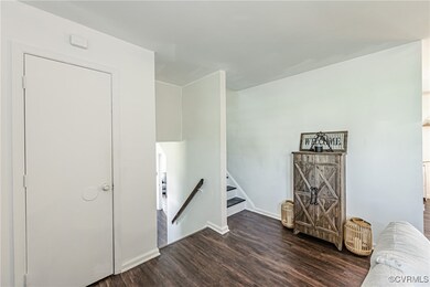 Living area with baseboards, stairs, and dark wood