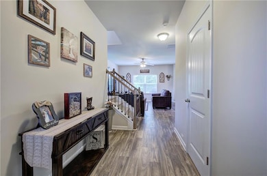 Hall with dark wood finished floors, stairway, and baseboards