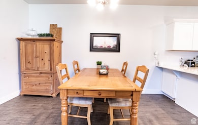 Dining space with dark wood-style floors and baseboards