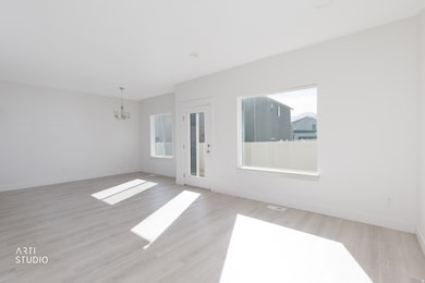 Unfurnished room featuring a chandelier and light wood-style flooring