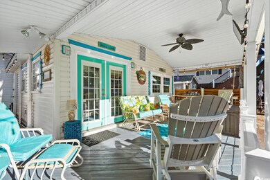 Wooden terrace with a ceiling fan, outdoor lounge area, and french doors