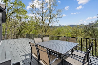Wooden deck with a wooded view and outdoor dining area