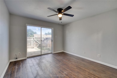 Empty room with dark wood-type flooring and ceiling fan