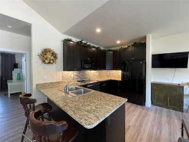 Kitchen featuring backsplash, sink, black applianc