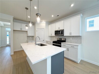 The kitchen which features a center island, quartz