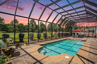 Pool at dusk with an outdoor pool, glass enclosure, and a sunroom