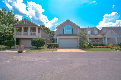 View of front of home with an attached garage, driveway, and brick siding