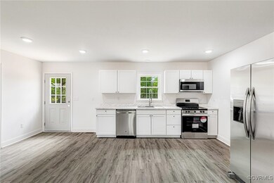 Kitchen with white cabinets, light countertops, ap