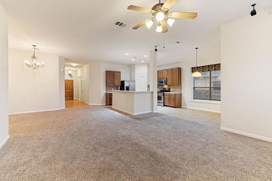 Unfurnished living room with light colored carpet, a chandelier, ceiling fan, and recessed lighting