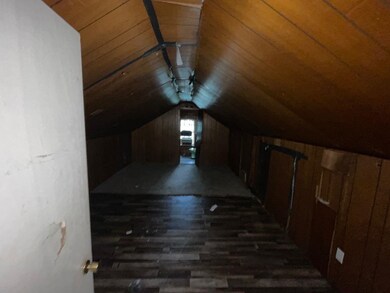 Additional living space with lofted ceiling, dark wood-style flooring, wood ceiling, and wooden walls