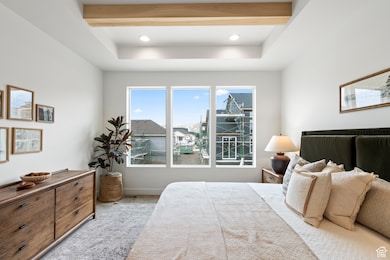 Carpeted bedroom with beam ceiling and recessed lighting