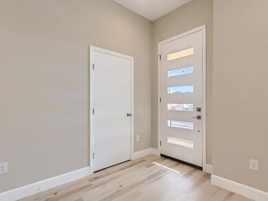 Foyer entrance with light wood-style floors and b