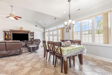 Dining area with plenty of natural light, high vaulted ceiling, ornamental molding, recessed lighting, and light tile patterned floors