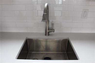 Kitchen view of light countertops and tasteful ba