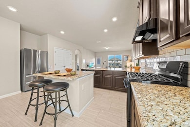 Kitchen featuring dark brown cabinets, black gas 