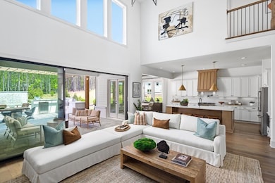 Living area with a towering ceiling, healthy amount of natural light, and wood finished floors