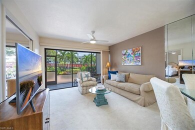 Carpeted living room featuring ceiling fan
