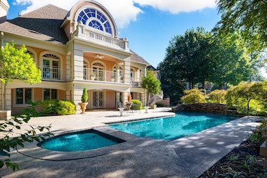 Rear view of house with french doors, a balcony, stucco siding, a patio area, and roof with shingles
