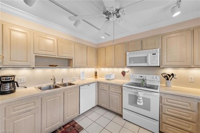 Kitchen with white appliances, rail lighting, light countertops, light tile patterned floors, and a ceiling fan