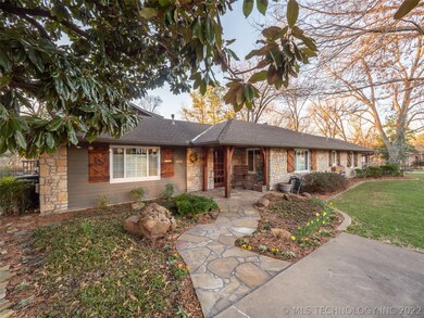 Charming curb appeal with lush landscaping and sto