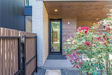 Doorway to property with a gate and brick siding