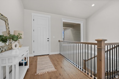 Entryway with light wood-style floors, lofted ceiling, and recessed lighting