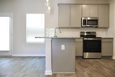 Kitchen featuring stainless steel appliances, gray cabinetry, and backsplash