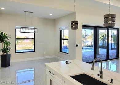 Kitchen featuring light stone counters, white cabi