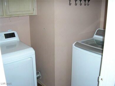 Laundry room featuring cabinet space and washer an