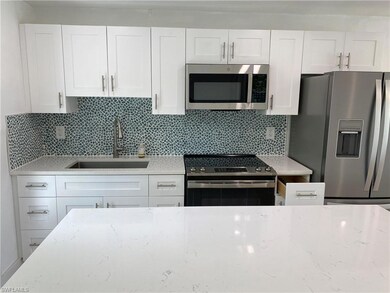 Kitchen with decorative backsplash, sink, white ca
