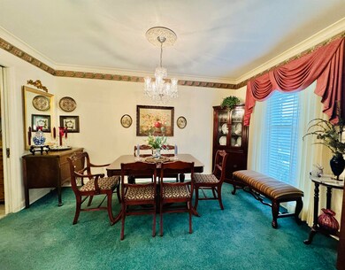 Dining room with dark colored carpet, a chandelier