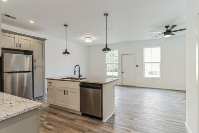 Kitchen featuring pendant lighting, sink, gray cab